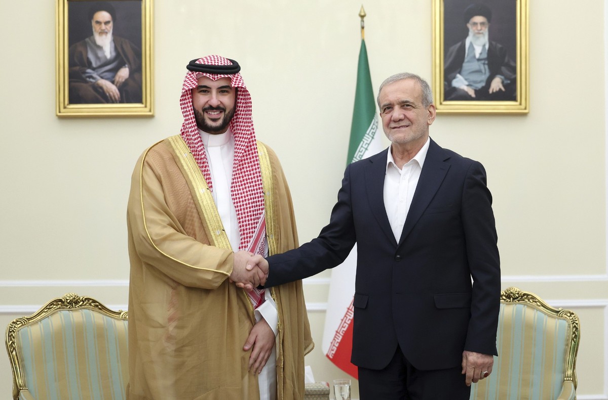 In this photo released by the Iranian Presidency Office, President Masoud Pezeshkian, right, shakes hands with Saudi Arabia&#039;s Defense Minister Prince Khalid bin Salman at the start of their meeti ...