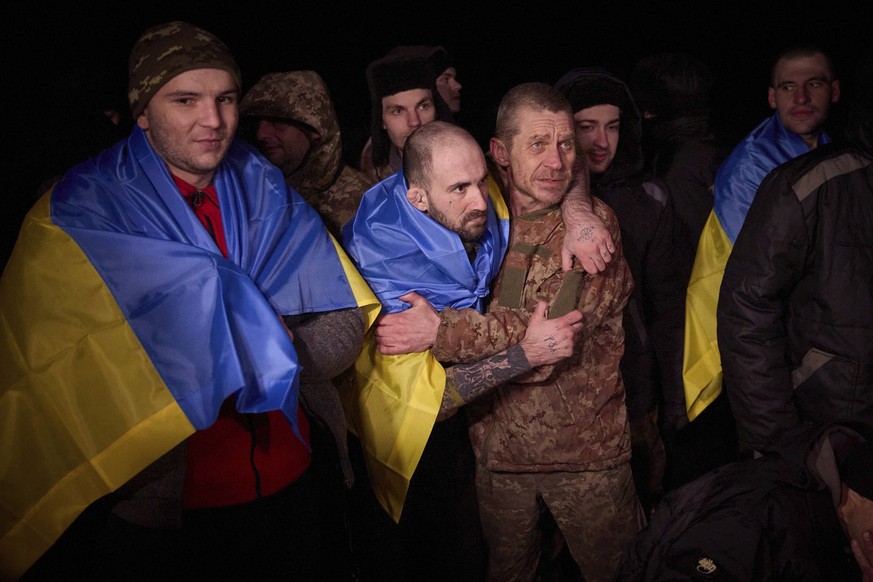 HANDOUT - 03.01.2024, Ukraine, Sumy: Auf diesem vom Pressebüro des ukrainischen Präsidenten zur Verfügung gestellten Foto tragen ukrainische Kriegsgefangene nach einem Gefangenenaustausch ukrainische  ...