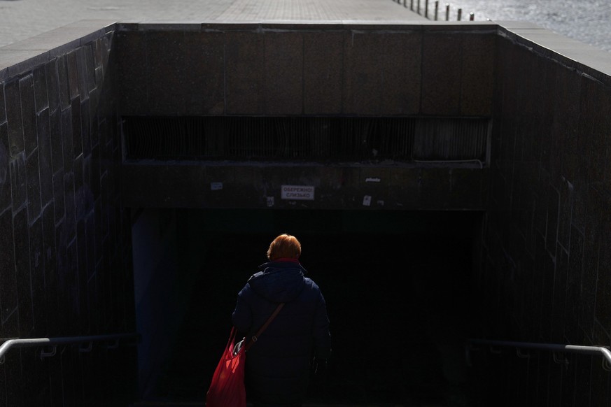 A woman walks into a metro station in downtown Kyiv, Ukraine, Thursday, Feb. 23, 2023. (AP Photo/Thibault Camus)