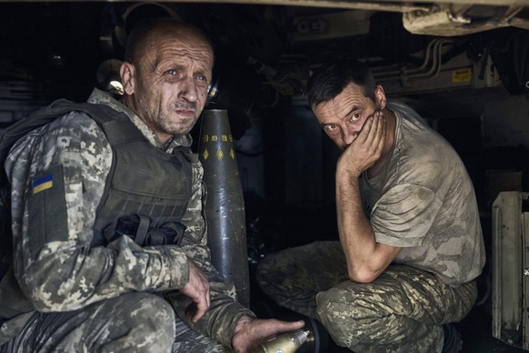 09.08.2023, Ukraine, ---: Ukrainische Soldaten sitzen in einer Panzerhaubitze an der Frontlinie. Foto: Libkos/AP/dpa +++ dpa-Bildfunk +++