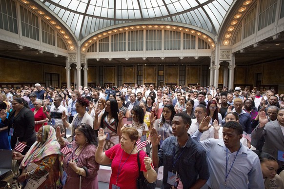 Two hundred immigrants from 50 countries take the oath of citizenship in a naturalization ceremony, Tuesday, July 3, 2018, at the New York Public Library's Celeste Bartos Forum. (AP Photo/Mark Lenniha ...