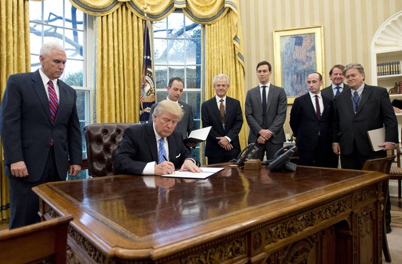 January 23, 2017 - Washington, District of Columbia, U.S. - U.S. President DONALD TRUMP signs the first of three Executive Orders in the Oval Office of the White House. Trump signed three executive or ...
