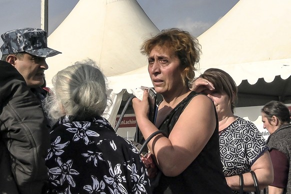 In this image taken from video, an ethnic Armenian woman cries as she and other refugees from the first group of about 30 people from Nagorno-Karabakh gather in a temporary camp after arriving to Arme ...