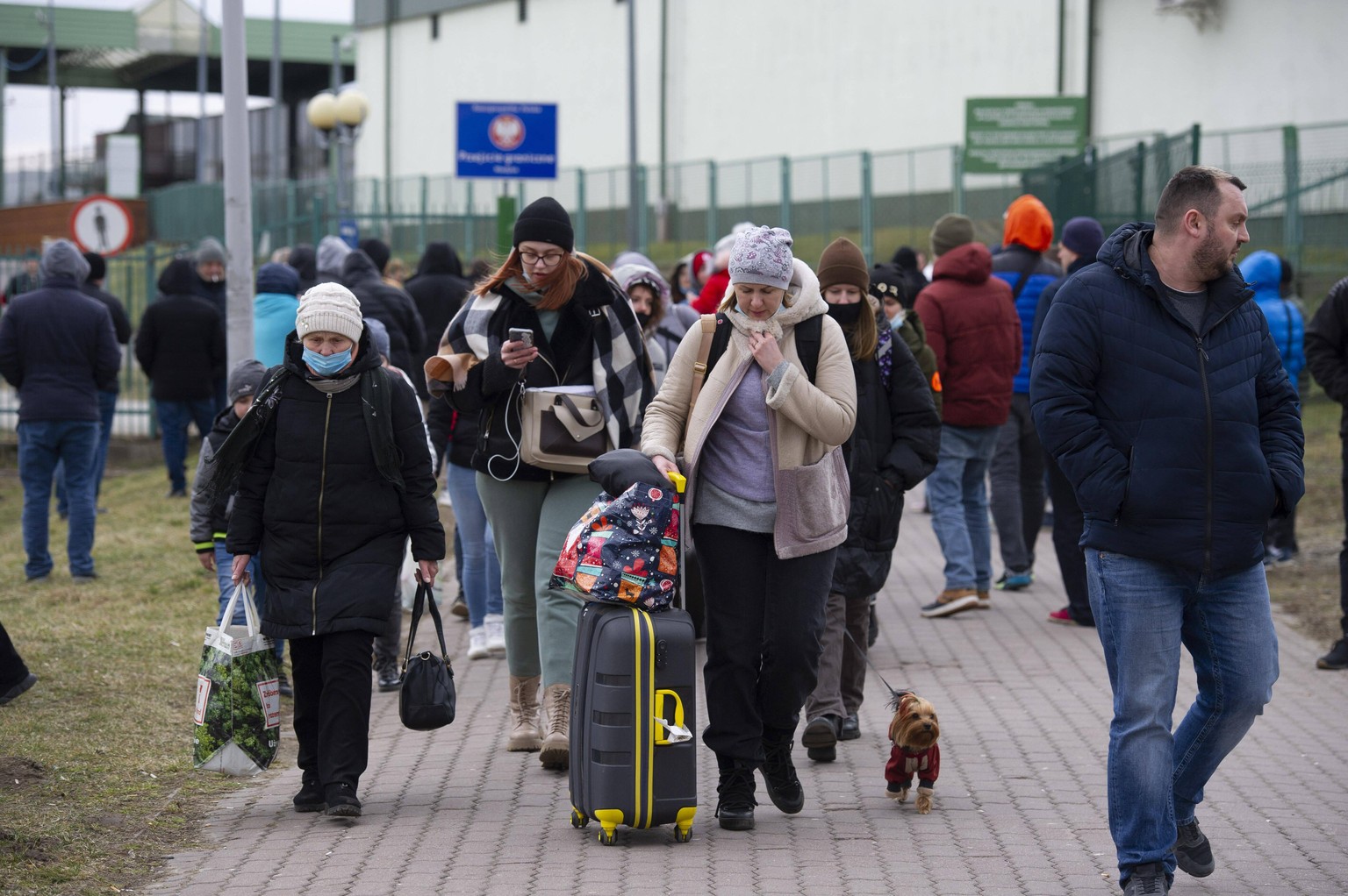 February 25, 2022, Medyka, Warsaw, Poland: People from Ukraine carry baggages as they cross the Polish Belarusian border on February 25, 2022 in Medyka, Poland. Thousands of people fleeing war in Ukra ...