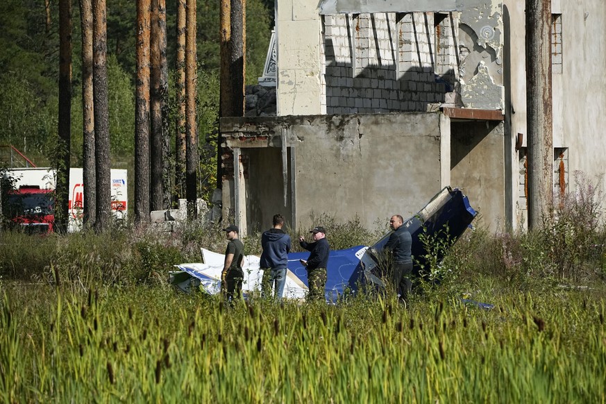 24.08.2023, Russland, Kushenkino: Russische Soldaten inspizieren ein Teil eines abgestürzten Privatjets. Der russische Söldnerführer Jewgeni Prigoschin ist nach Angaben seines Telegram-Kanals Grey Zon ...