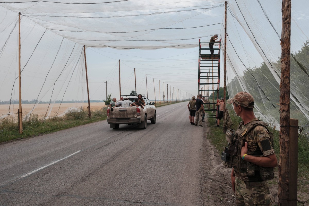 July 12, 2025, Donbas, Ukraine: On the road between Kramatorsk and Dobropillia, Ukrainian soldiers install fishing nets to help prevent drone attacks, particularly FPV drones equipped with fiber-optic ...