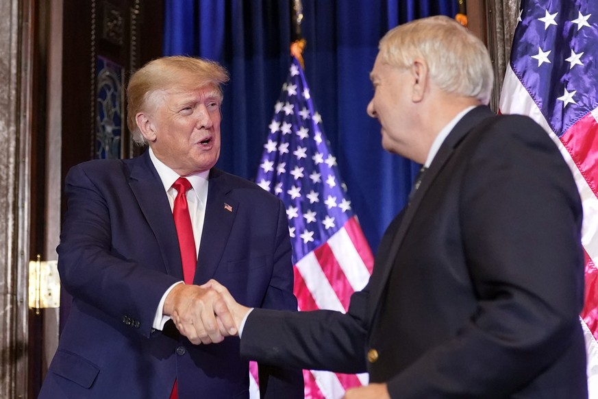 28.01.2023, USA, Columbia: Donald Trump (l), ehemaliger Präsident der USA, schüttelt Senator Lindsey Graham, Republikaner aus South Carolina, die Hand, als er bei einer Wahlkampfveranstaltung im South ...