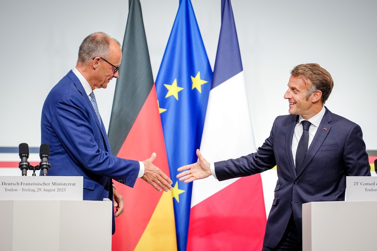 29.08.2025, Frankreich, Toulon: Bundeskanzler Friedrich Merz (CDU, l) und Frankreichs Präsident Emmanuel Macron reichen sich beim deutsch-französischen Regierungstreffen zur Wirtschafts- und Sicherhei ...