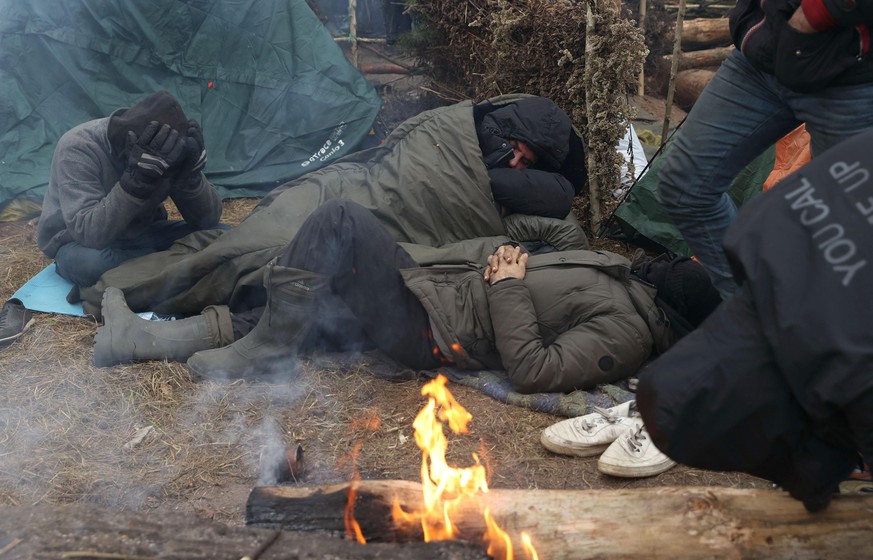 GRODNO REGION, BELARUS - NOVEMBER 14, 2021: Migrants in a tent camp on the Belarusian-Polish border. The migrant crisis on the border of Belarus with Poland, Lithuania, and Latvia escalated on Novembe ...