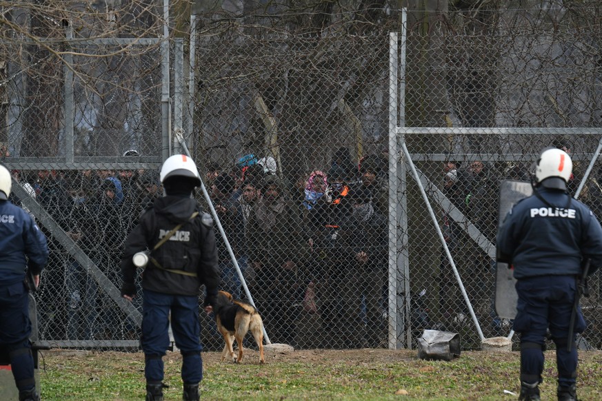 Migrants who want to cross into Greece from Turkey are gathered at the borderline as Greek riot police stand guard, at the closed Kastanies border crossing with Turkey's Pazarkule, in the region of Ev ...