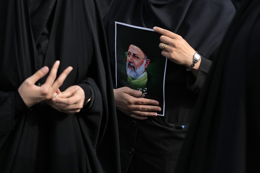 20.05.2024, Iran, Teheran: Eine iranische Frau hält ein Bild von Präsident Ebrahim Raisi während einer Trauerfeier für ihn auf dem Vali-e-Asr-Platz im Zentrum von Teheran. Der iranische Präsident Rais ...