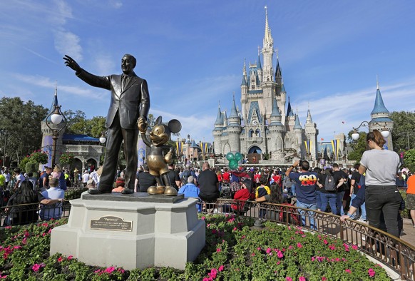FILE - In this Jan. 9, 2019 photo, a statue of Walt Disney and Micky Mouse stands in front of the Cinderella Castle at the Magic Kingdom at Walt Disney World in Lake Buena Vista, Fla. The Walt Disney  ...