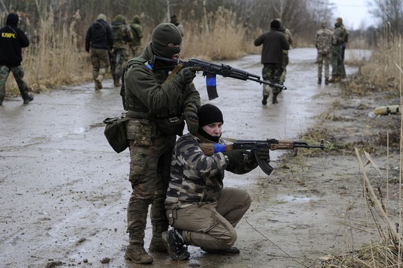 24.02.2023, Ukraine, Lwiw: Zivilisten nehmen an einer militärischen Übung des Prawyj Sektors, einer rechtsextremen ukrainischen politischen Organisation, in der Nähe von Lwiw teil. Die russische Armee ...