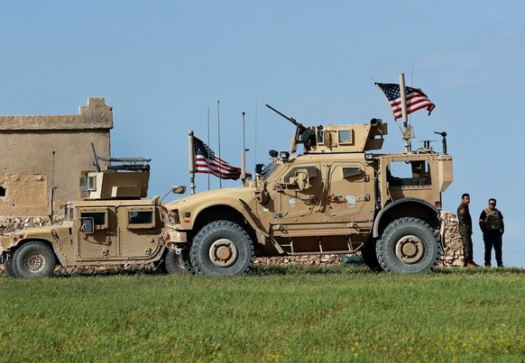 FILE -- In Thursday, March 29, 201 file photo, a fighter, second from right, of U.S-backed Syrian Manbij Military Council is parked next to U.S. humvee at a U.S. troop's outpost on a road leading to t ...