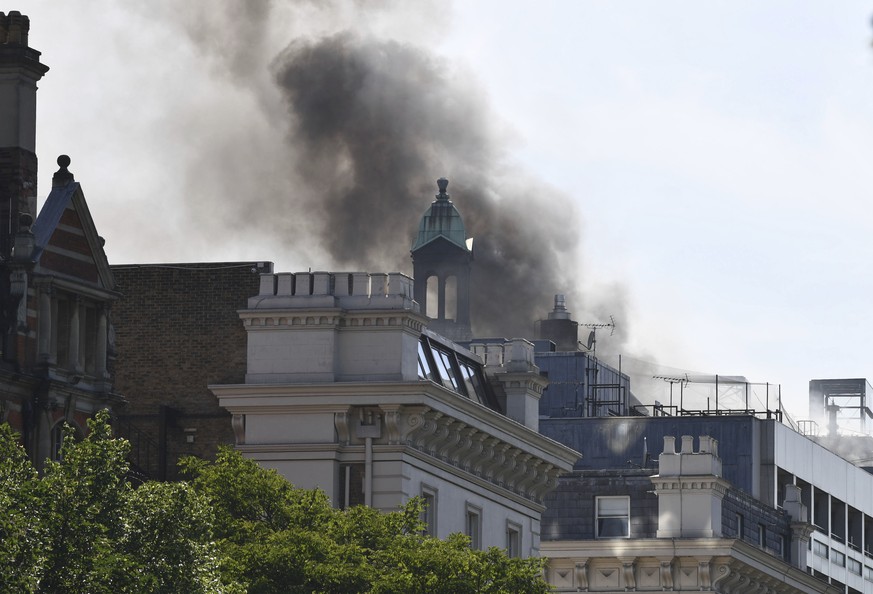 Smoke rises from a building in Knightsbridge, central London, as London Fire Brigade responded to a call of a fire in this upmarket location, Wednesday June 6, 2018. (John Stillwell/PA via AP)