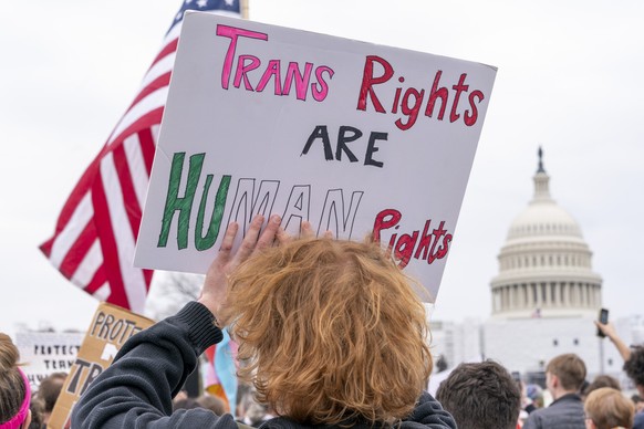 People attend a rally as part of a Transgender Day of Visibility, Friday, March 31, 2023, by the Capitol in Washington. Transgender people and their allies gathered at venues across the country Friday ...