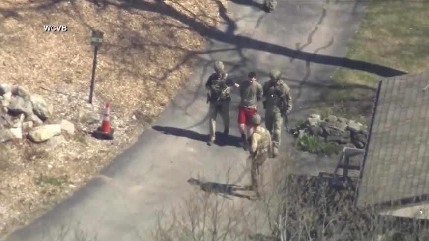 13.04.2023, USA, Dighton: Dieses Bild aus einem von WCVB-TV zur Verfügung gestellten Video zeigt Jack T. in T-Shirt und Shorts, der von bewaffneten Einsatzkräften in Gewahrsam genommen wird. Bei dem i ...