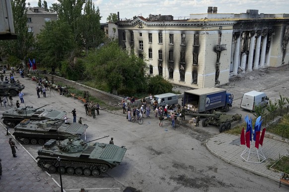 12.07.2022, Ukraine, Lyssytschansk: Anwohner stehen an, um humanit