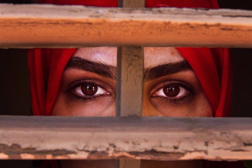 May 1, 2023, Barcelona, Spain: LIZA ANVARY, an Afghan refugee, looks through a window frame she says represents the prison like situation of women in her country. Liza worked for the Afghan government ...