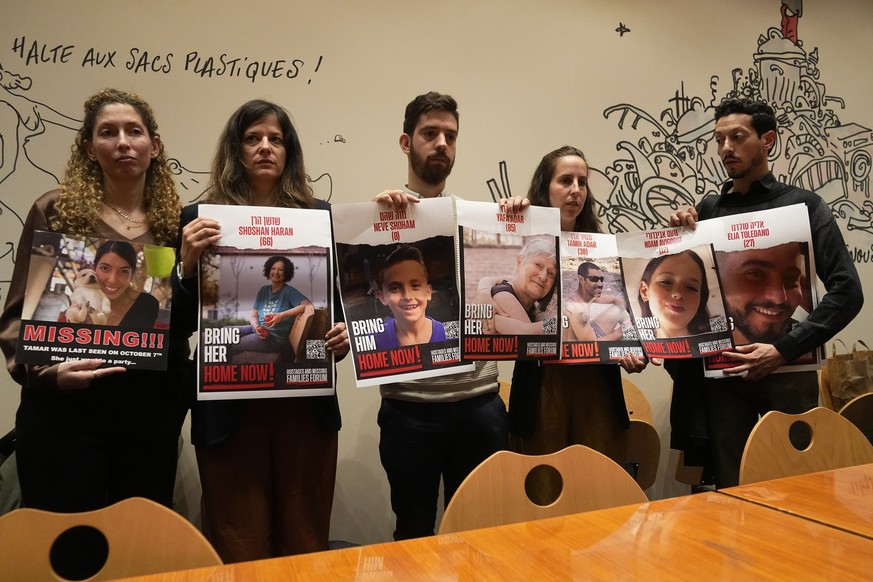 From the left, Adva Gutman, Ayelet Sela bin Nun, Alon Adar, Adva Adar and Daniel Toledano, hold portraits of relatives held hostages by the Hamas militants during a press conference at the Paris town  ...