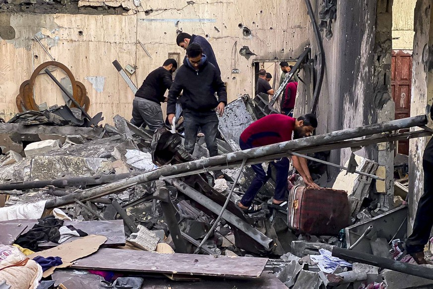 People react between the debris caused by explosions at Al Sabura refugee camp, in Rafah, Gaza and West Bank, 13 December 2023. Although considered a humanitarian zone, the area that includes the Al S ...