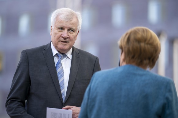 BERLIN, GERMANY - SEPTEMBER 15: Federal Interior Minister Horst Seehofer (CSU) speaks to German Chancellor Angela Merkel (CDU) at the celebration to mark the 70th anniversary of Germany&#039;s Central ...