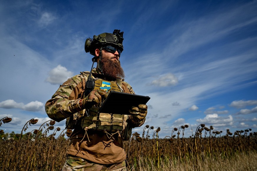 Mortar Crew Serves In Zaporizhzhia Region - Ukraine A soldier of a military mortar crew checks the direction on the tablet as he stands on the border of a dry sunflower field, Zaporizhzhia Region, sou ...