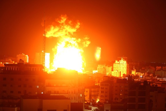 May 17, 2021, Gaza, Gaza Strip, Palestinian Territory: Fire and smoke rise above buildings in Gaza City as Israeli warplanes target the Palestinian enclave. Deadly violence erupted across the West Ban ...