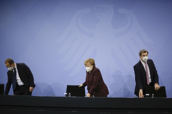 German Chancellor Angela Merkel, center, Bavarian state governor Markus Soeder, right, and the Mayor of Berlin Michael Mueller, left, arrive for a news conference after a meeting at the chancellery in ...