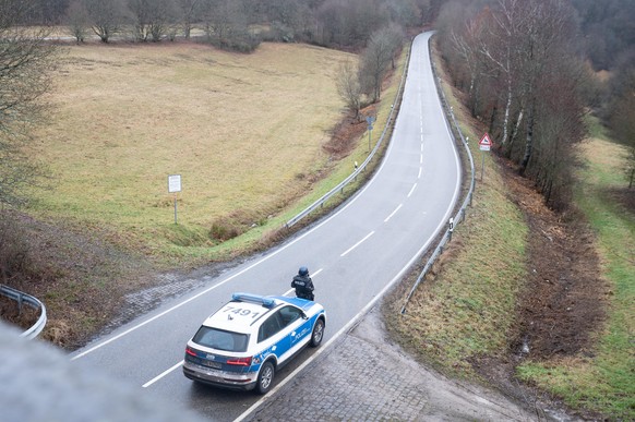 Polizeibeamte stehen an einer Absperrung an der Kreisstraße 22, rund einen Kilometer von dem Tatort entfernt, an dem zwei Polizeibeamte durch Schüsse getötet wurden. Die tödlichen Schüsse fielen nach  ...