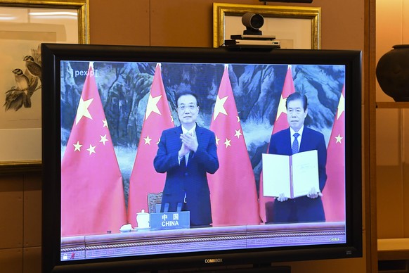 SCOTT MORRISON RCEP SIGNING CEREMONY, Chinese Minister for Commerce Zhong Shan and Chinese Premier Li Keqiang are seen on screen after signing the Regional Comprehensive Economic Partnership RCEP duri ...