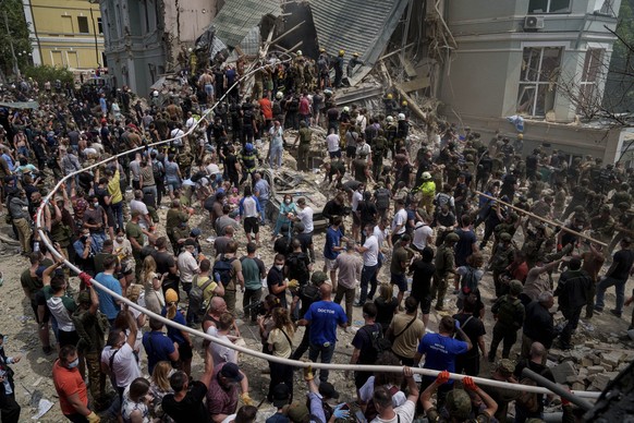 08.07.2024, Ukraine, Kiew: Rettungskräfte arbeiten an dem von russischen Raketen getroffenen Okhmatdyt-Kinderkrankenhaus. Russische Raketen haben mehrere Menschen getötet und ein Kinderkrankenhaus in  ...