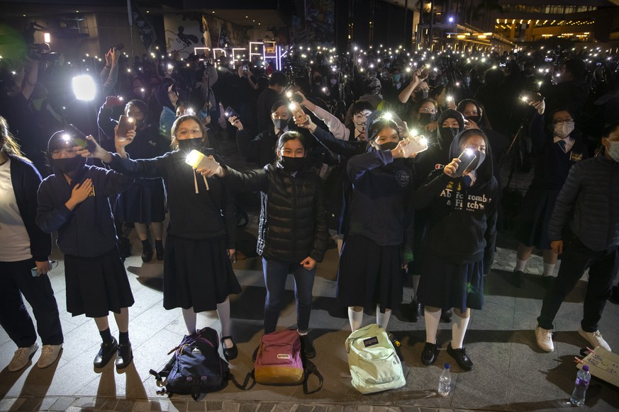 Protesters wave their smartphones as they sing &quot;Glory to Hong Kong&quot; during a rally for secondary school students near the Hong Kong Museum of Art in Hong Kong, Friday, Dec. 13, 2019. Protest ...