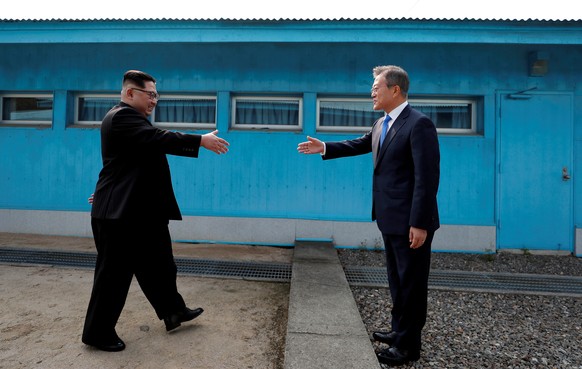 FILE PHOTO: South Korean President Moon Jae-in and North Korean leader Kim Jong Un (L) are about to shake hands on their first ever meeting at the truce village of Panmunjom inside the demilitarized z ...