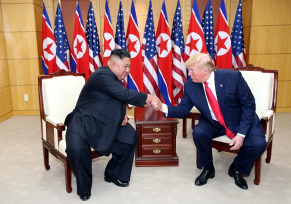 PANMUNJOM, SOUTH KOREA - JUNE 30 (SOUTH KOREA OUT): A handout photo provided by Dong-A Ilbo of North Korean leader Kim Jong Un and U.S. President Donald Trump attend a meeting on the south side of the ...