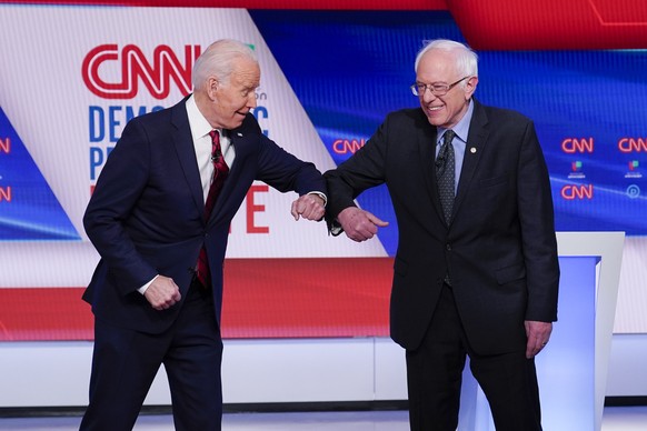 FILE - In this March 15, 2020 file photo, now Democratic presidential candidate former Vice President Joe Biden, left, and Sen. Bernie Sanders, I-Vt., right, greet one another before they participate  ...