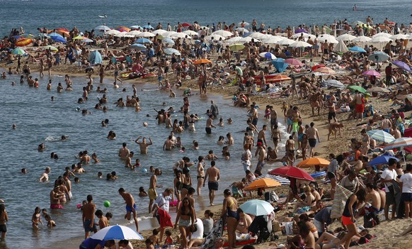 People sunbathe on a beach in Barcelona, Spain, Wednesday, Aug. 1, 2018. Much of Spain is on alert as the country's weather agency warns that temperatures could surpass 40 degrees Celsius (104 Fahrenh ...