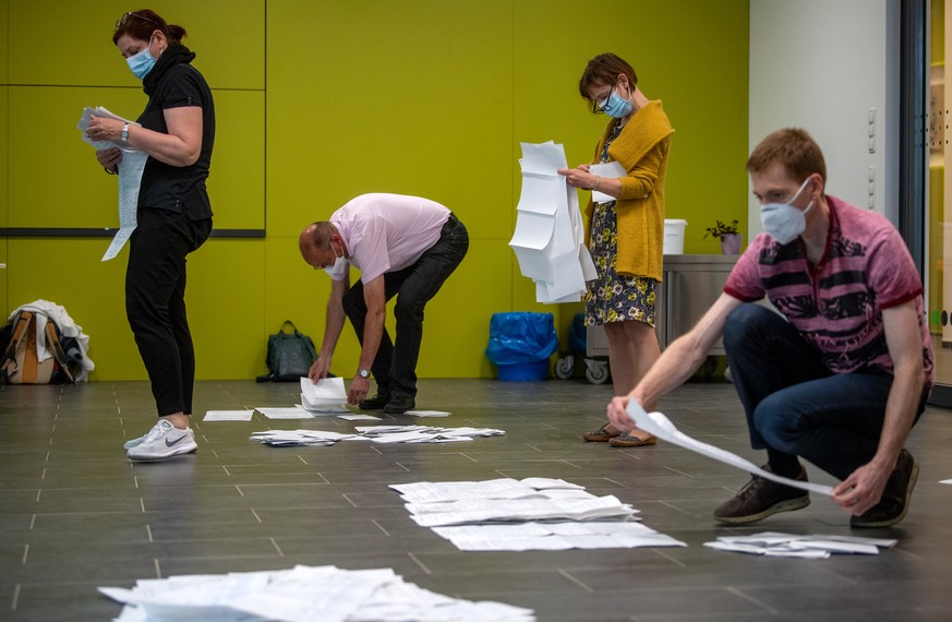 06.06.2021, Sachsen-Anhalt, Magdeburg: Wahlhelfer sortieren die Stimmzettel zum Beginn der Ausz