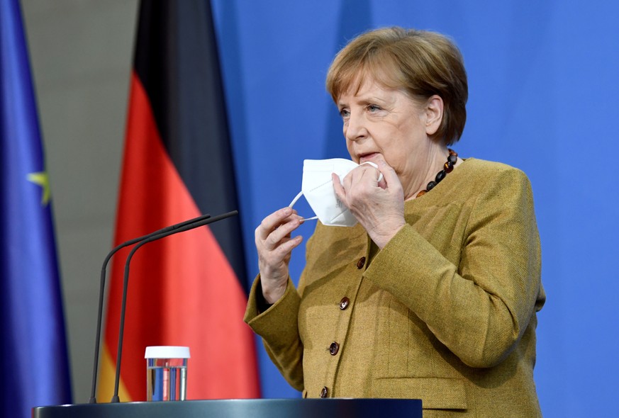 19.02.2021, Berlin: Bundeskanzlerin Angela Merkel (CDU) zieht sich vor einer Pressekonferenz im Anschluss an den virtuellen G7-Gipfel eine Maske ab. Foto: Annegret Hilse/Reuters/Pool/dpa +++ dpa-Bildf ...
