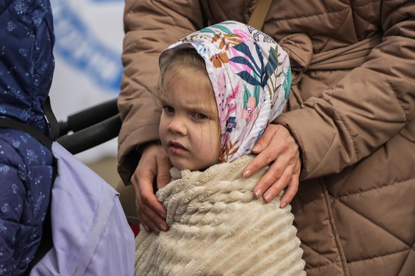 A refugee child waits in a line after fleeing the war from neighboring Ukraine at the border crossing in Medyka, southeastern Poland, Sunday, April 10, 2022. (AP Photo/Sergei Grits)