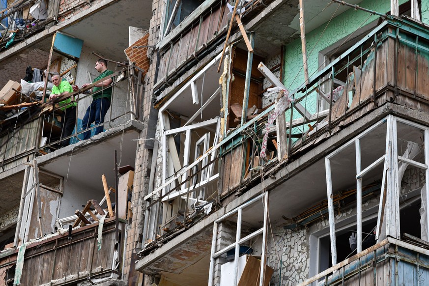 Kramatorsk im Osten der Ukraine: Zwei Männer stehen auf dem Balkon eines beschossenen Hauses.