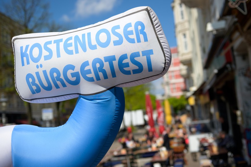 «Kostenloser Bürgertest» steht auf einem aufblasbaren Hinweisschild zwischen Restaurants im Schanzenviertel. Der rot-grüne Hamburger Senat wird am Dienstag über das weitere Vorgehen nach Auslaufen der ...