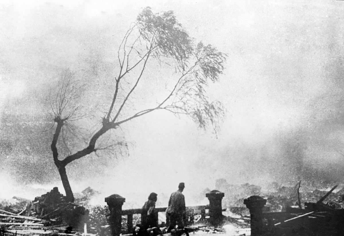 ARCHIV - 09.08.1945, Japan, Nagasaki: �berlebende des Atombombenangriffs gehen durch Tr�mmer, w�hrend im Hintergrund Feuer w�ten. Am 9. August 1945 um 11.02 Uhr warf ein US-Bomber die Atombombe �Fat M ...