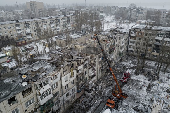 15.02.2023, Ukraine, Pokrowsk: Rettungskräfte räumen die Trümmer des, nach ukrainischen Angaben, von einer russischen Rakete zerstörten Wohnhauses. Foto: Evgeniy Maloletka/AP/dpa +++ dpa-Bildfunk +++