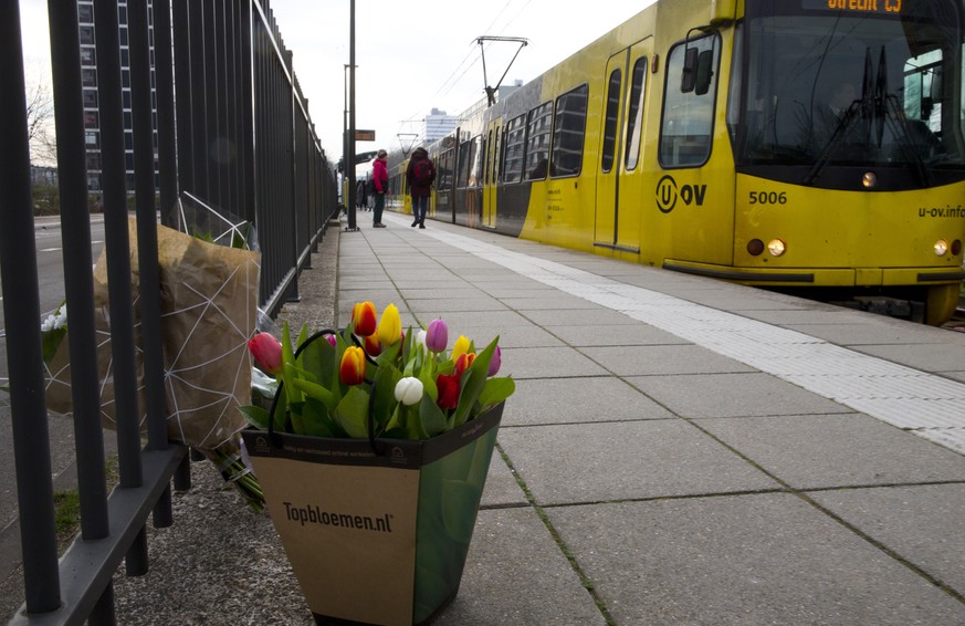 A tram passes flowers at the site of a shooting incident in a tram in Utrecht, Netherlands, Tuesday, March 19, 2019. A gunman killed three people and wounded others on a tram in the central Dutch city ...