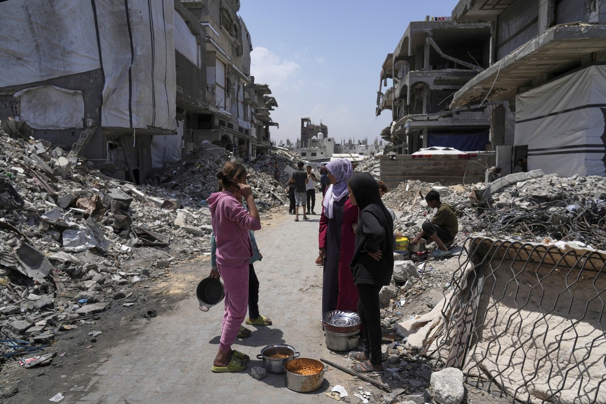 Palestinians receive donated food at a community kitchen in Beit Lahia, northern Gaza Strip, Saturday, May 3, 2025. (AP Photo/Jehad Alshrafi)