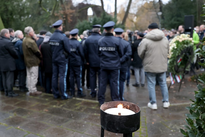 23.01.2025, Bayern, Aschaffenburg: Trauernde stehen nach einer Kranzniederlegung nach dem t