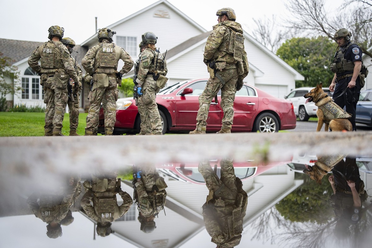 Armed FBI agents have a meeting to strategize as they search for an active shooter by sweeping a neighborhood adjacent to the home of Minnesota DFL State Representative Melissa Hortman, in Brooklyn Pa ...