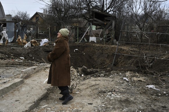 Tamara Makshanova 75, stands near a crater left by the Russian rocket that damaged her home in Zaporizhzhya, Ukraine, Thursday, Jan. 12, 2023. (AP Photo/Andriy Andriyenko)