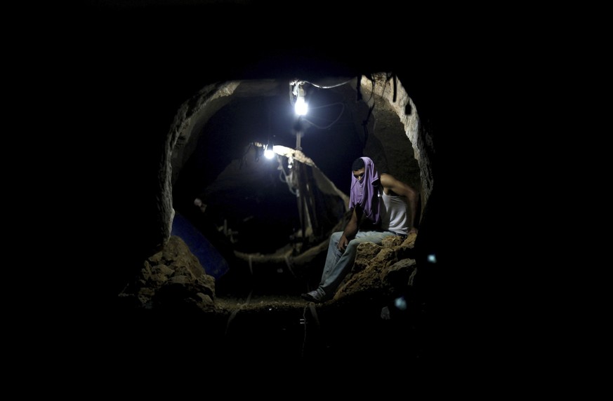 FILE - A Palestinian worker rests inside a smuggling tunnel in Rafah, on the border between Egypt and the southern Gaza Strip Sept. 30, 2013. An extensive labyrinth of tunnels built by Hamas stretches ...
